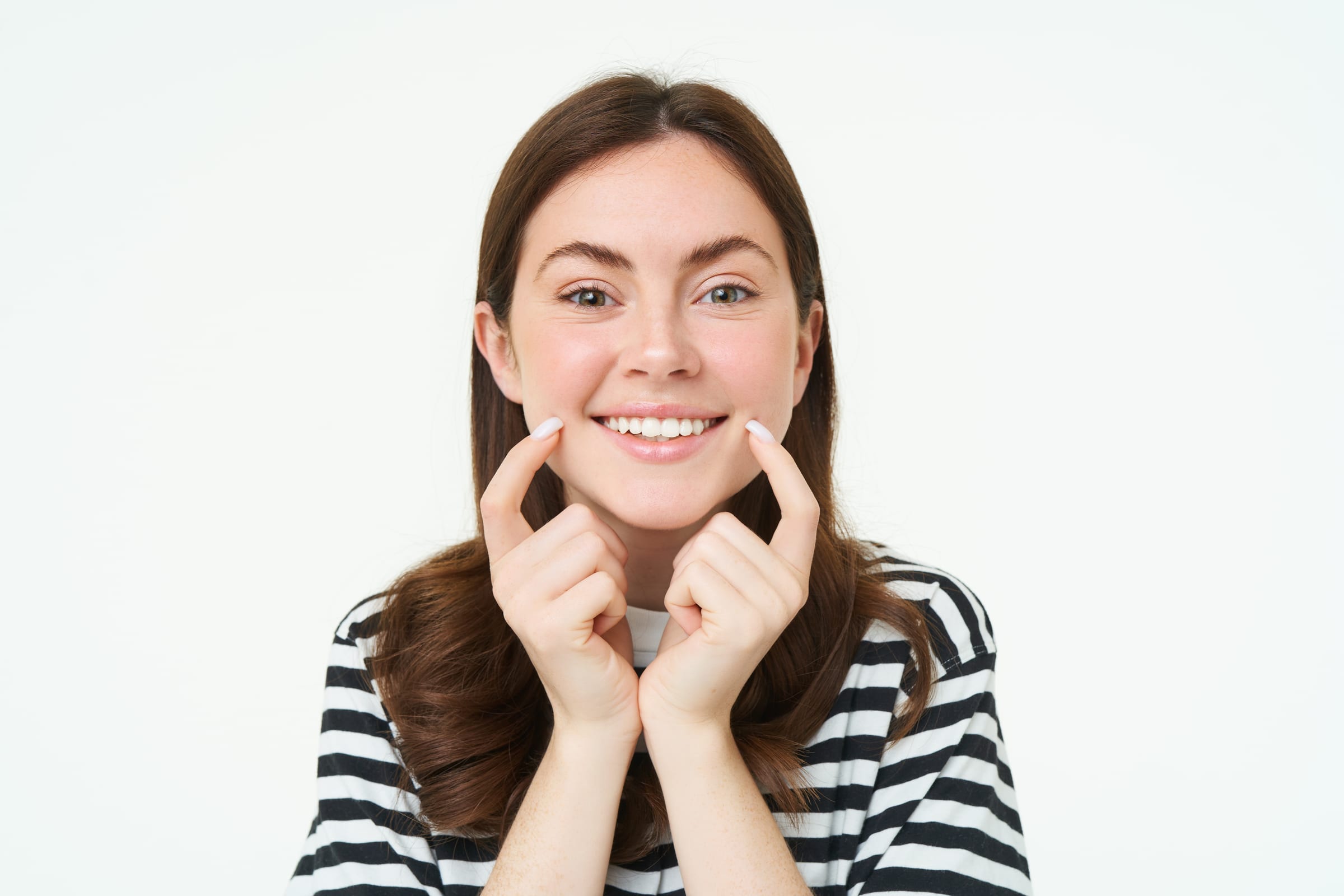 Woman pointing to her smile with dimples
